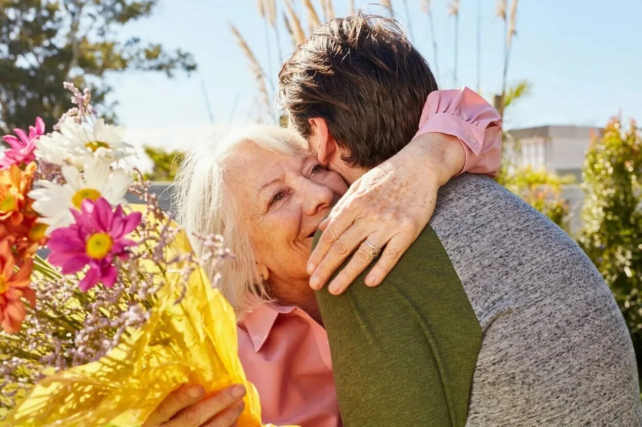 Пожилые мамы видео. Мужчина дарит цветы маме. Дарите матерям цветы. Пожилой мужчина дарит цветы. Маме дарят цветы.