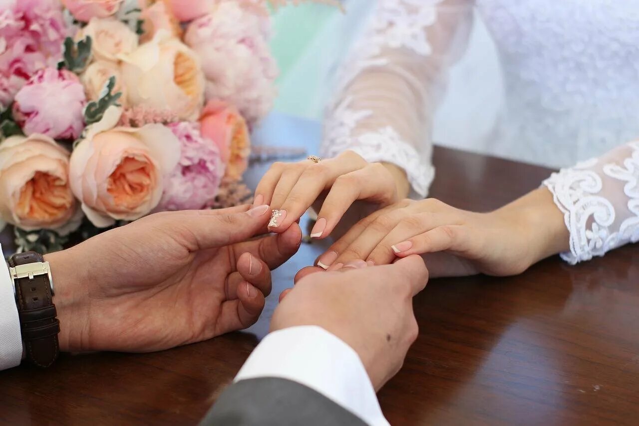 Замужество суть. Молодожены в ЗАГСЕ. Вступающим в брак. Вступление в брак. Обручальное кольцо на руке невесты.