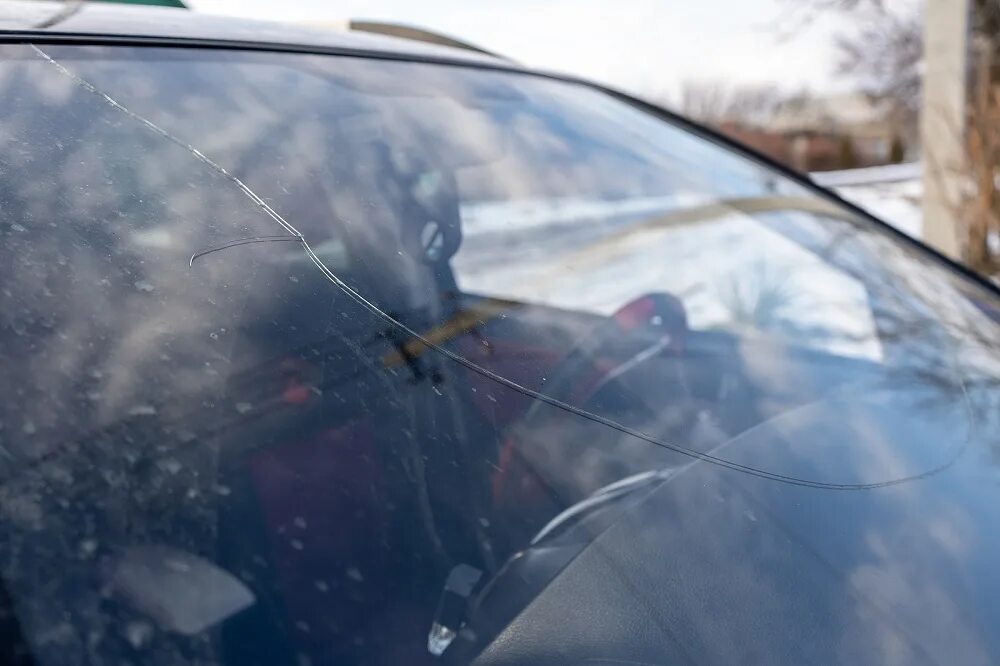 Портит стекло. Трещина на стекле авто зимой. Машина с разбитым лобовым стеклом. Трещины на лобовом стекле в зимнее время. Скрытые повреждения на автомобиле.