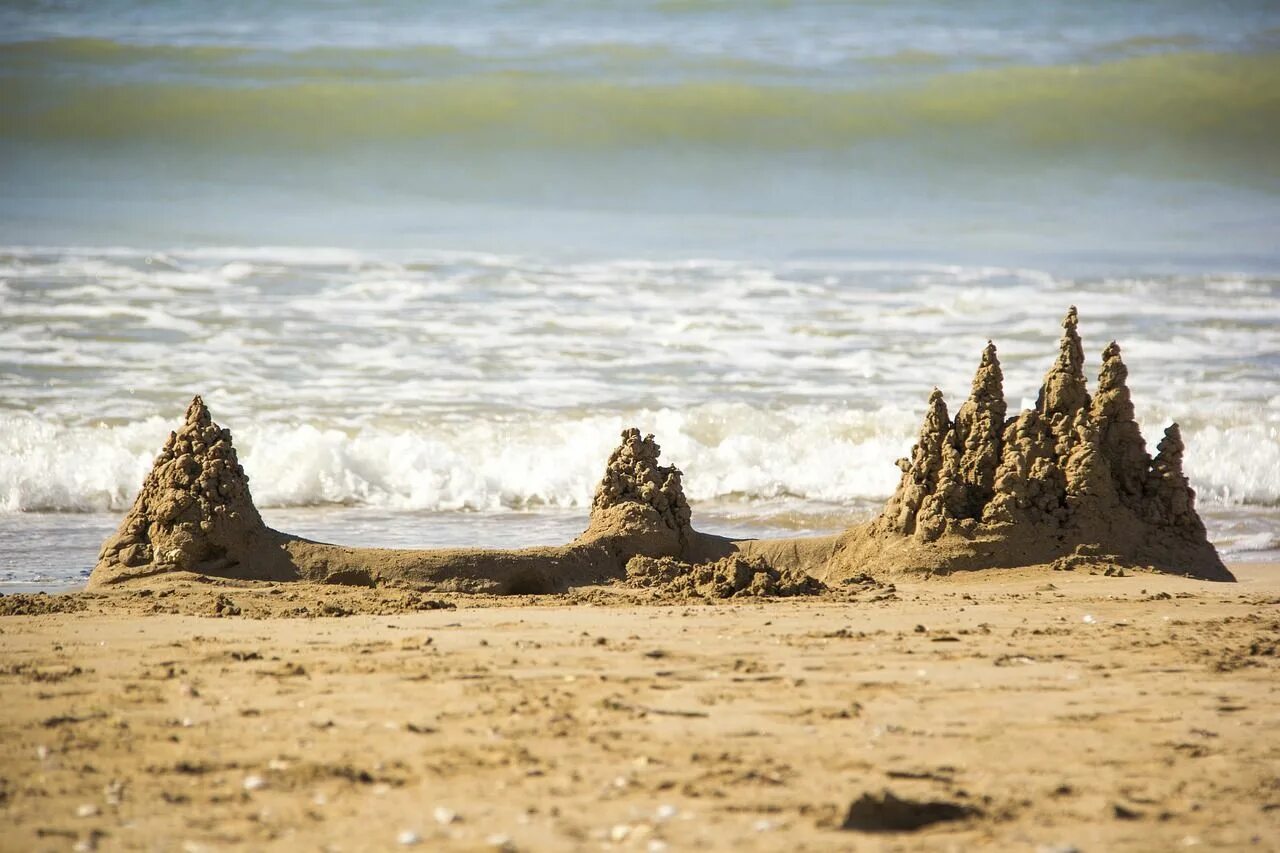 Sandcastle picture. Замок из песка. Замок из песка на пляже. Песочный замок на берегу моря. Город из песка.