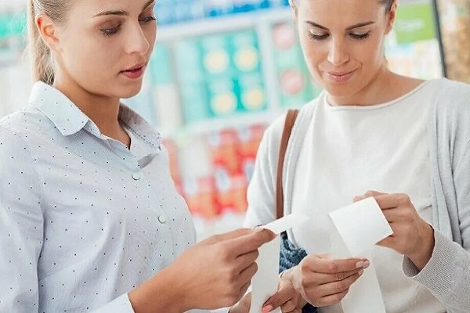 Price matching. Женщина сравнивает предметы. Woman checking the Price. Женщина сравнивает размер упаковки в магазине.