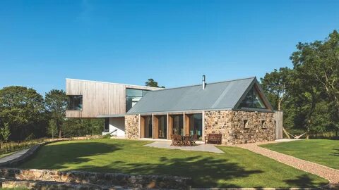 timber clad cantilever extension to stone cottage.