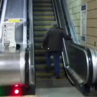 Человек идущий вниз по эскалатору