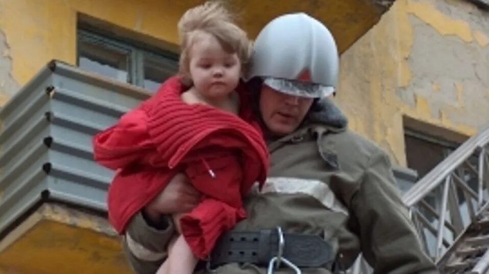 Мужчина выносивший ребенка. Пожарный спасает ребенка. Пожарные спасают людей. МЧС спасает детей.