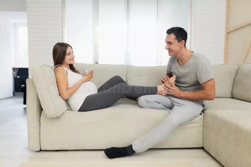 Муж сидит смотрит как жену. Мужчина и женщина сидят на диване. Девушка сидит рядом с диваном. Фотосессия с мужем на диване. Мужчина и женщина сидят рядом на диване.
