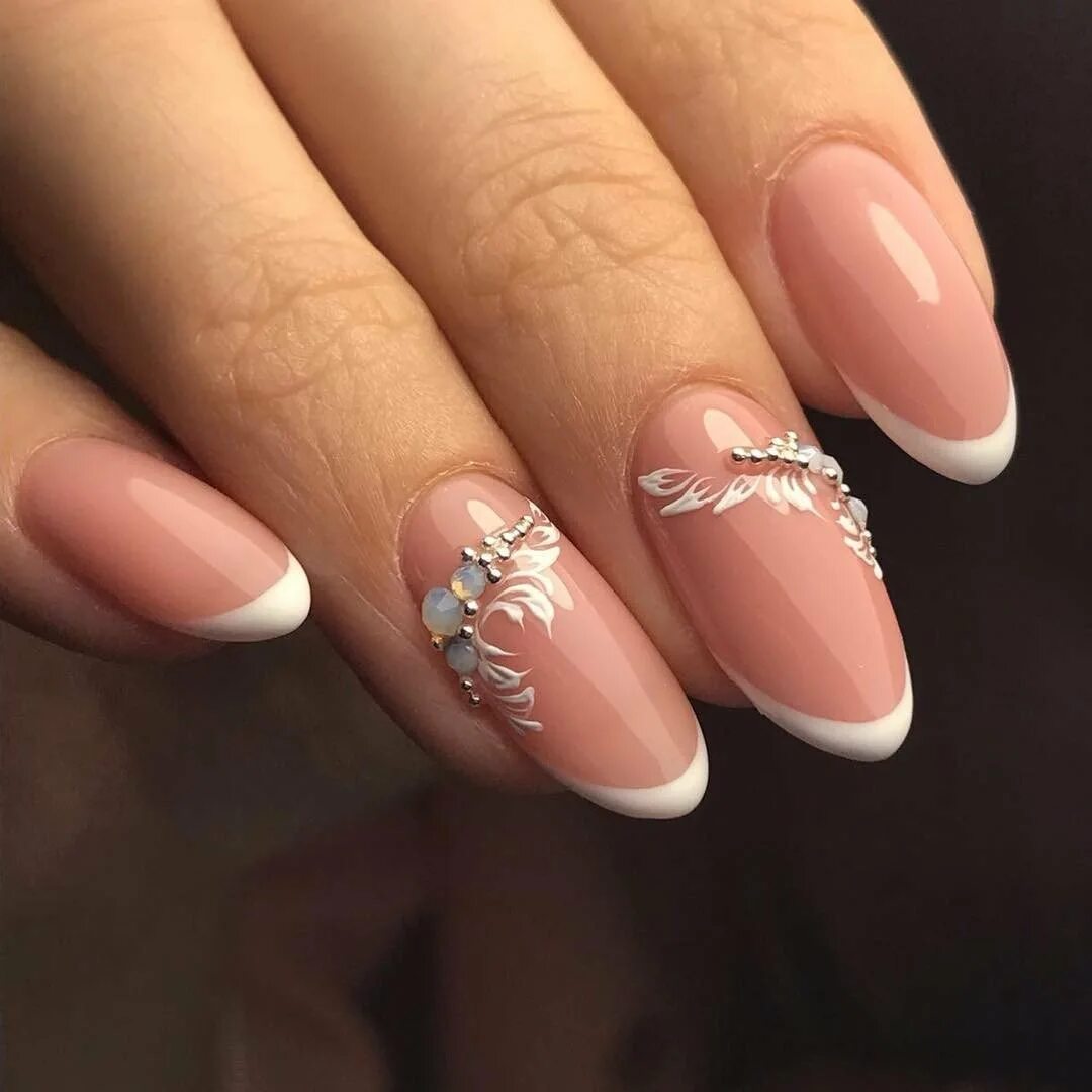 праздничный френч на ногтях. праздничный френч на ногтях. белый френч на миндалевидных ногтях 2022. белый маникюр со стразами и блестками. праздничный дизайн ногтей.