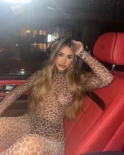 Ester Bron is wearing black dotted clothes and sitting in the car or posing...