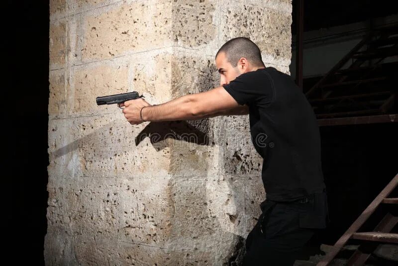Человек с пистолетом за стеной. Человек с пистолетом за углом. Человек у стены с оружием.