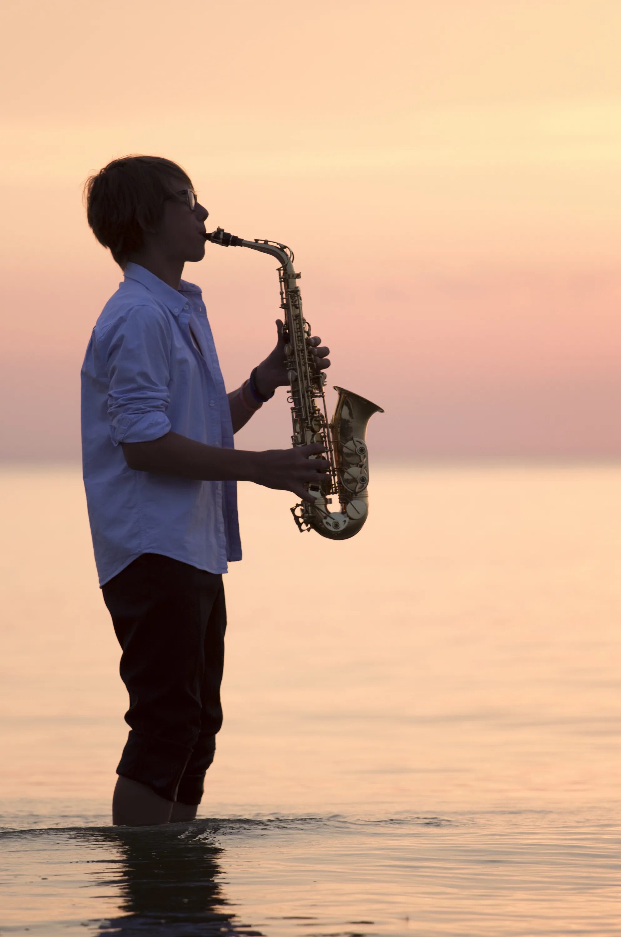Музыка саксофон без регистрации. Саксофон. Саксофонист на море. Человек с саксофоном. Мужчина играющий на саксофоне.