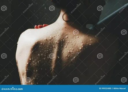 Back view of beautiful naked young woman taking shower. 
