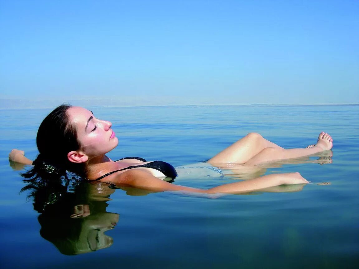 Купаться в соленой воде. Мертвое море. Купаться в море. Лежать на воде. Люди купаются в море.