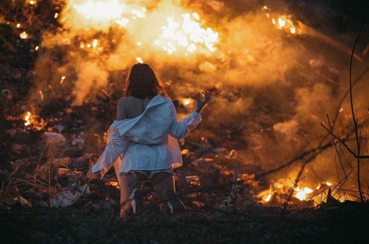 Девушка с огнем в лесу. Девушка пожар. Человек на фоне горящее дома. Девочка огонь.