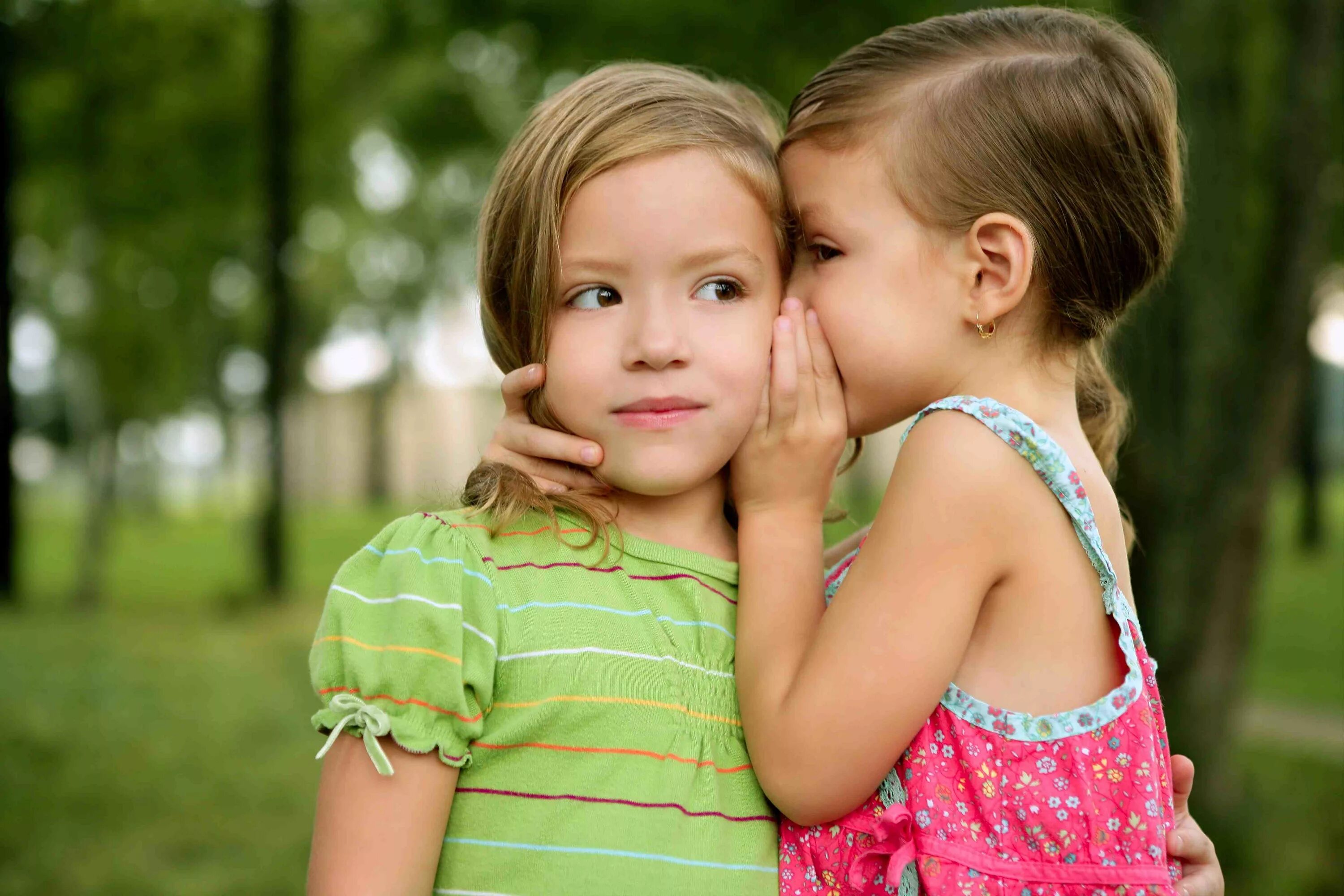 Two cute. Девочки подружки. Общение детей. Маленькие девочки болтают. Две девочки секретничают.