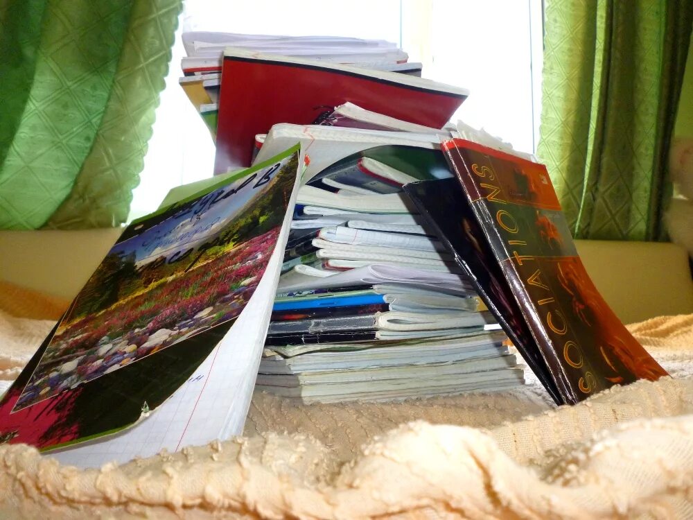 стопка школьных тетрадей. стопка тетрадок на столе. куча тетрадей. стопка тетрадей. стопка газет на столе.