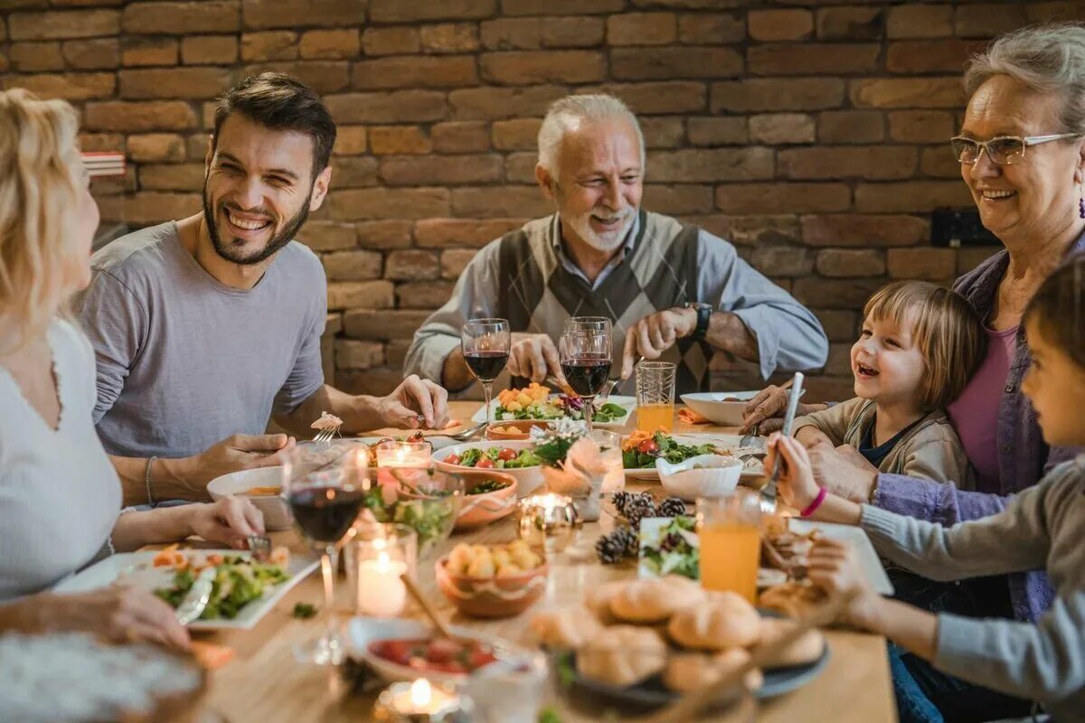 Friends dining. Семья за столом. Семья за праздничным столом. Большая семья за столом. Семейное застолье.