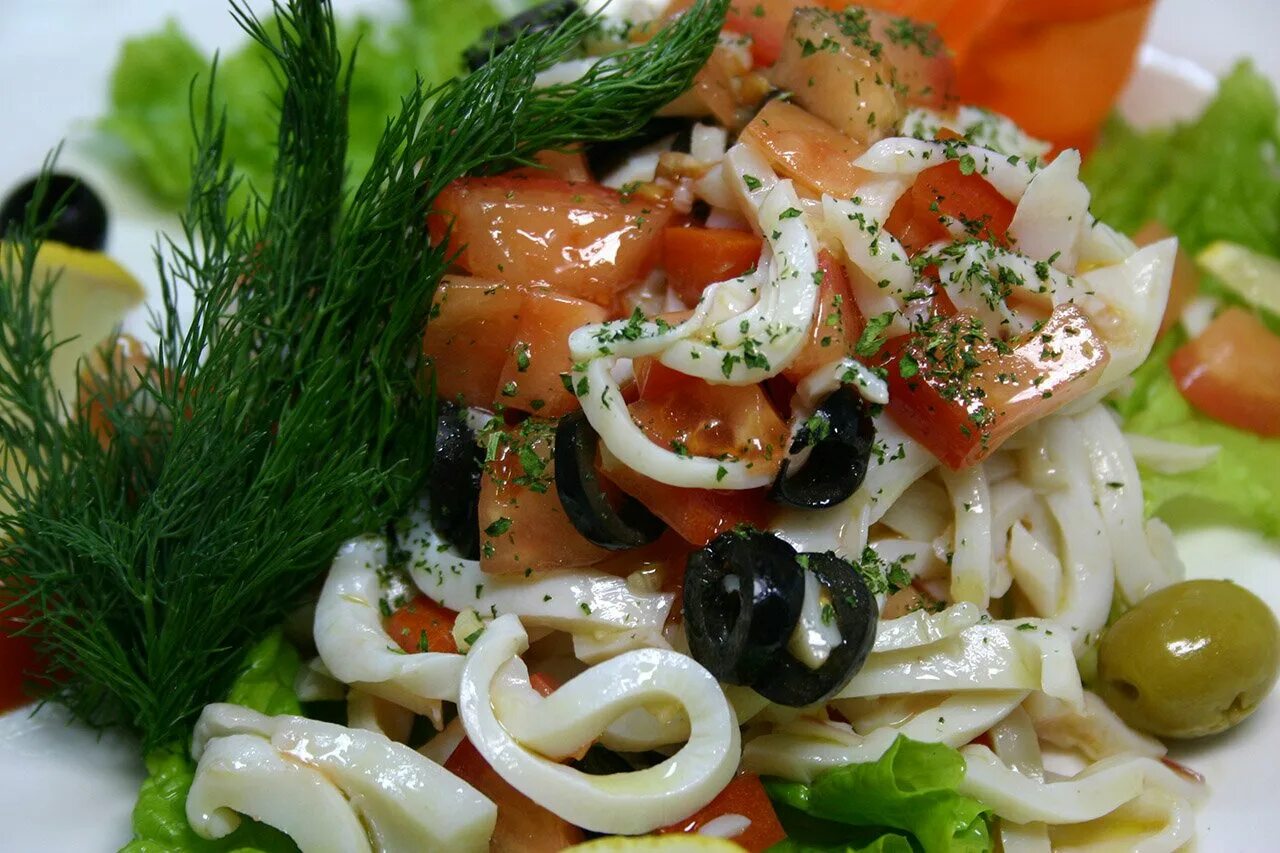 Кальмары в пост рецепты. Салат из кальмаров. Салат с кальмарами и маслинами. Салат с кальмаром ресторан. Салат с кальмарами и овощами.