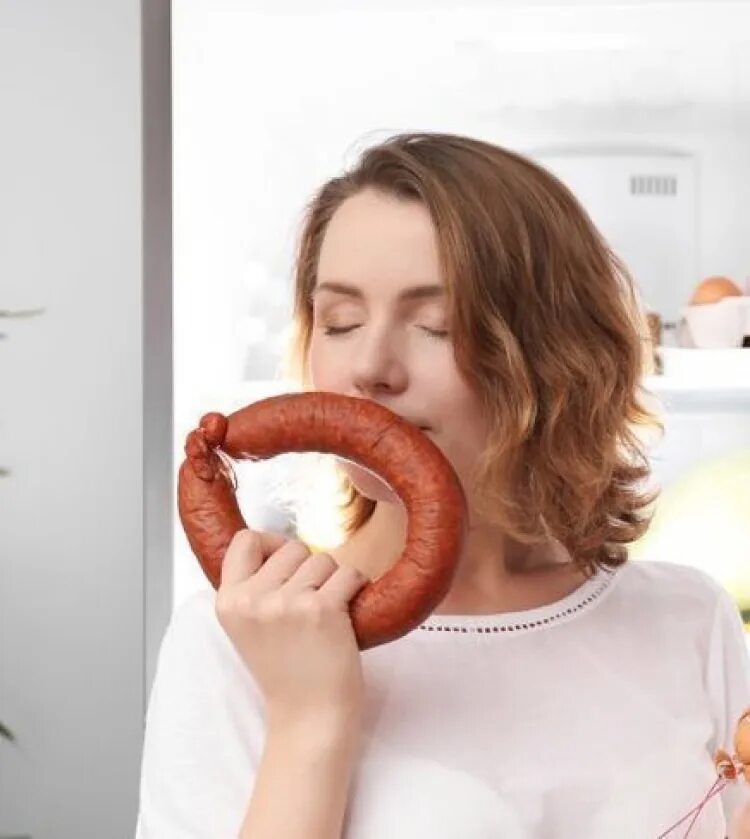 К чему снится есть колбасу. Кушает колбасу. женщина ест колбасу. человек ест колбасу.
