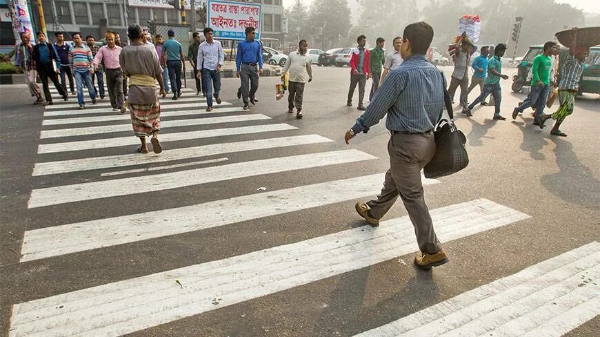 Человек переходит дорогу. Много пешеходов. Много людей переходят дорогу. Много людей на пешеходном переходе.
