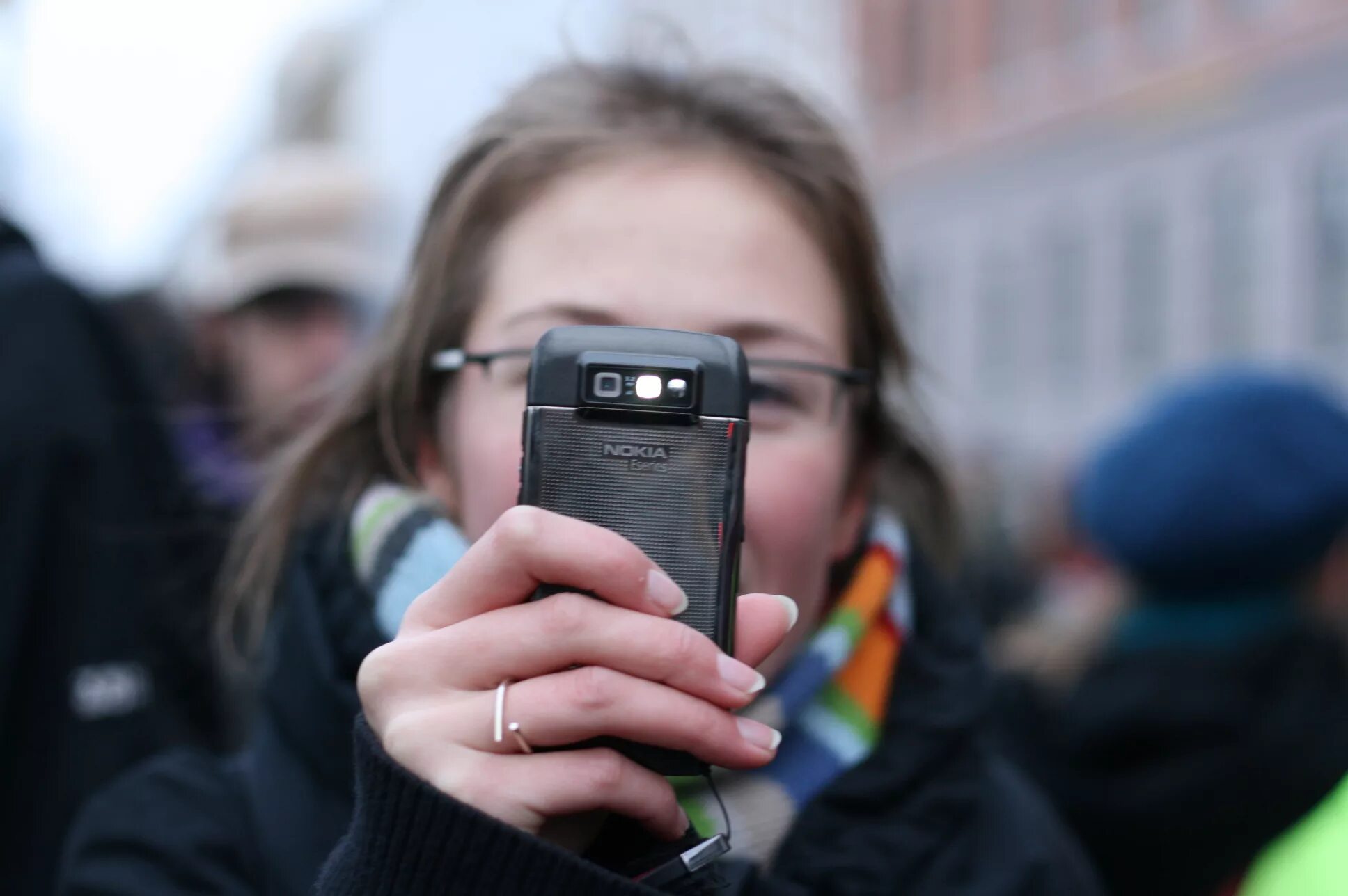 Видеосъемка на телефон. Подросток со смартфоном. Человек фотографирует на телефон. Человек с телефоном. Телефон мобильный на улице