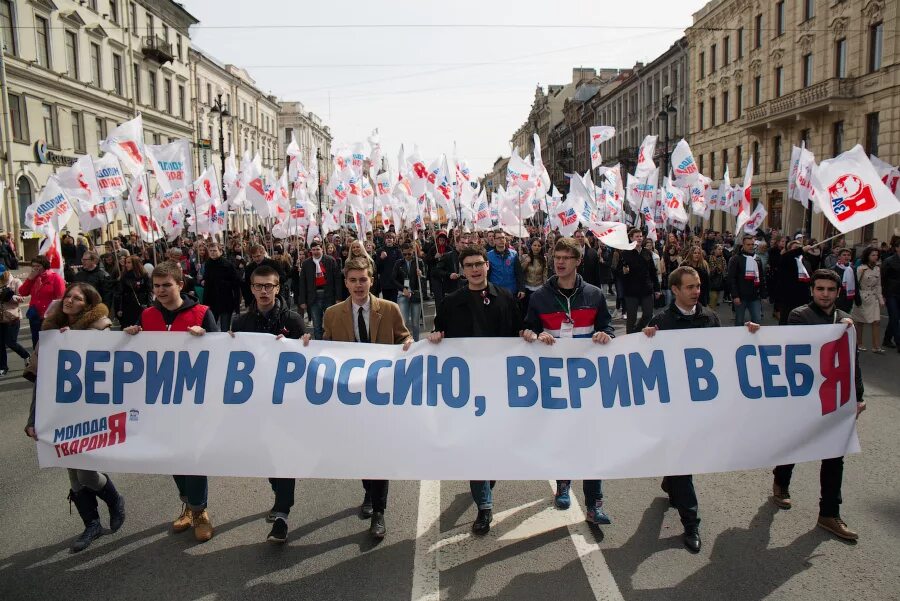 Демонстрация с транспарантами. Демонстранты с плакатами. Лозунги в поддержку России. Флаги на демонстрации. Единая россия верю в россию