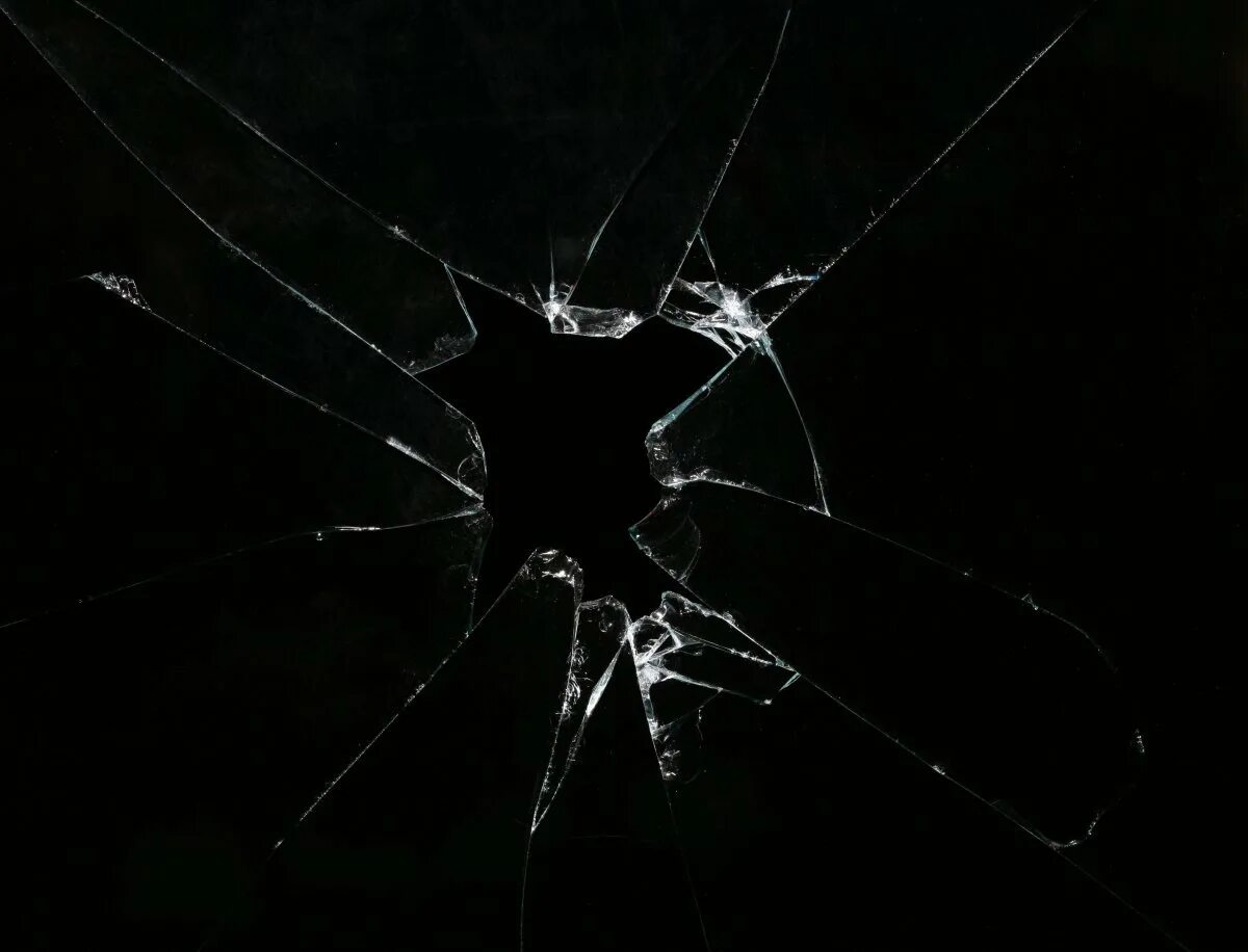 Задать разбитый. Разбитое стекло. Трещина на стекле. Треснутое стекло. Трушены на стекле на черном фоне.