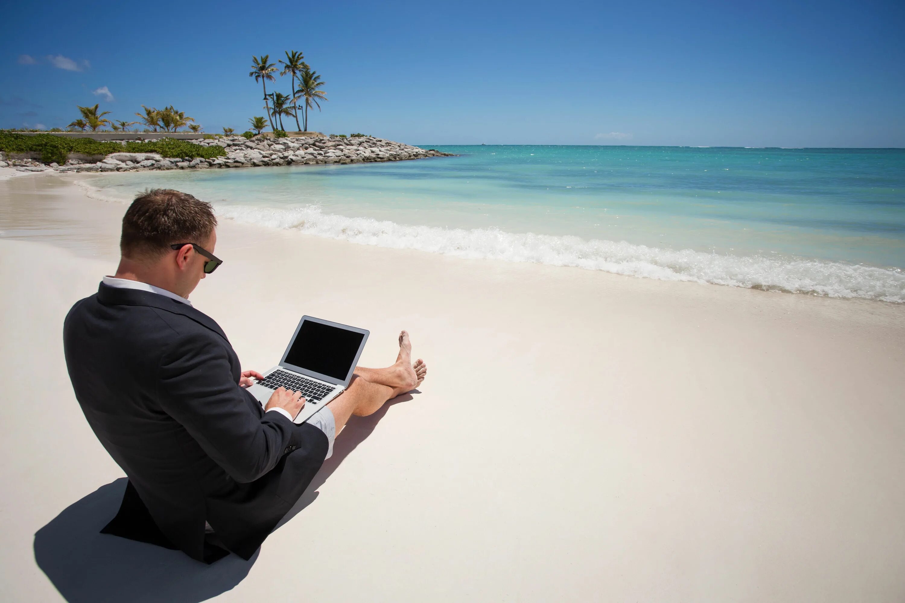 Человек с ноутбуком на пляже. Бизнесмен на море. Тестер пляжей. Работа на пляже. Управление из любой точки