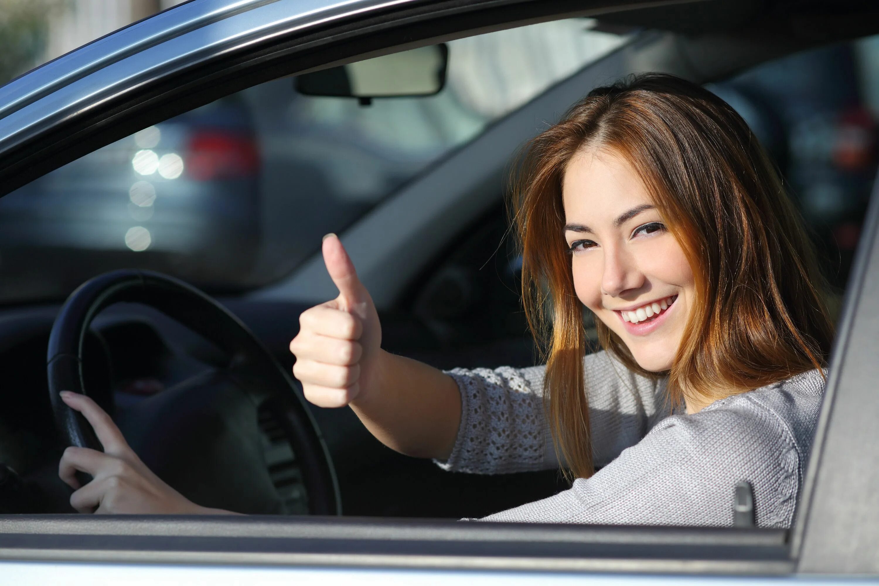 Driven student. Женщина за рулем. Девушка водитель. Девушка водит машину. Радостная девушка в машине.