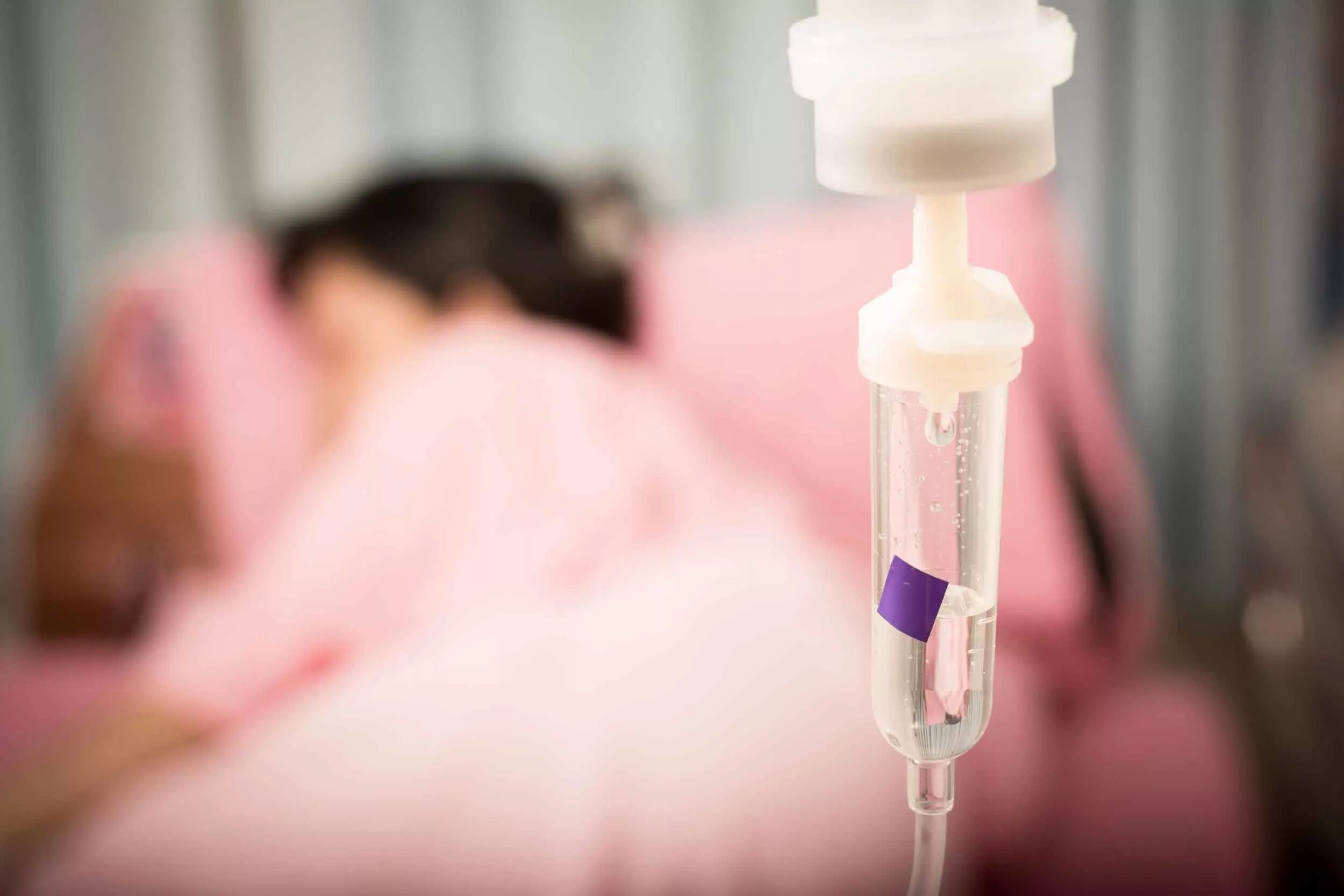 отделение химиотерапии. женщина на химиотерапии. химиотерапевтическое отделение онкологического диспансера. пациент на кушетке в больнице лежит. стационар химиотерапия.