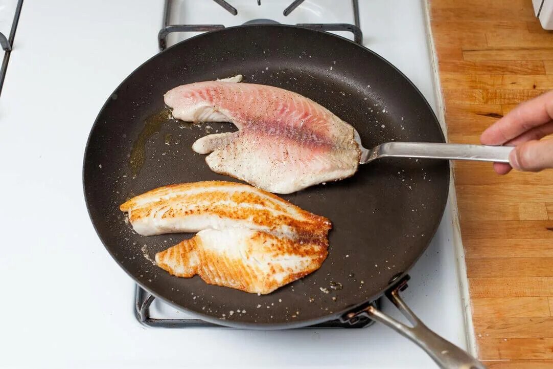 Какую рыбу жарят. Тилапия на сковороде. Филе тилапии на сковороде. Жареная рыба на сковороде. Жарит рыба на скаваротка.