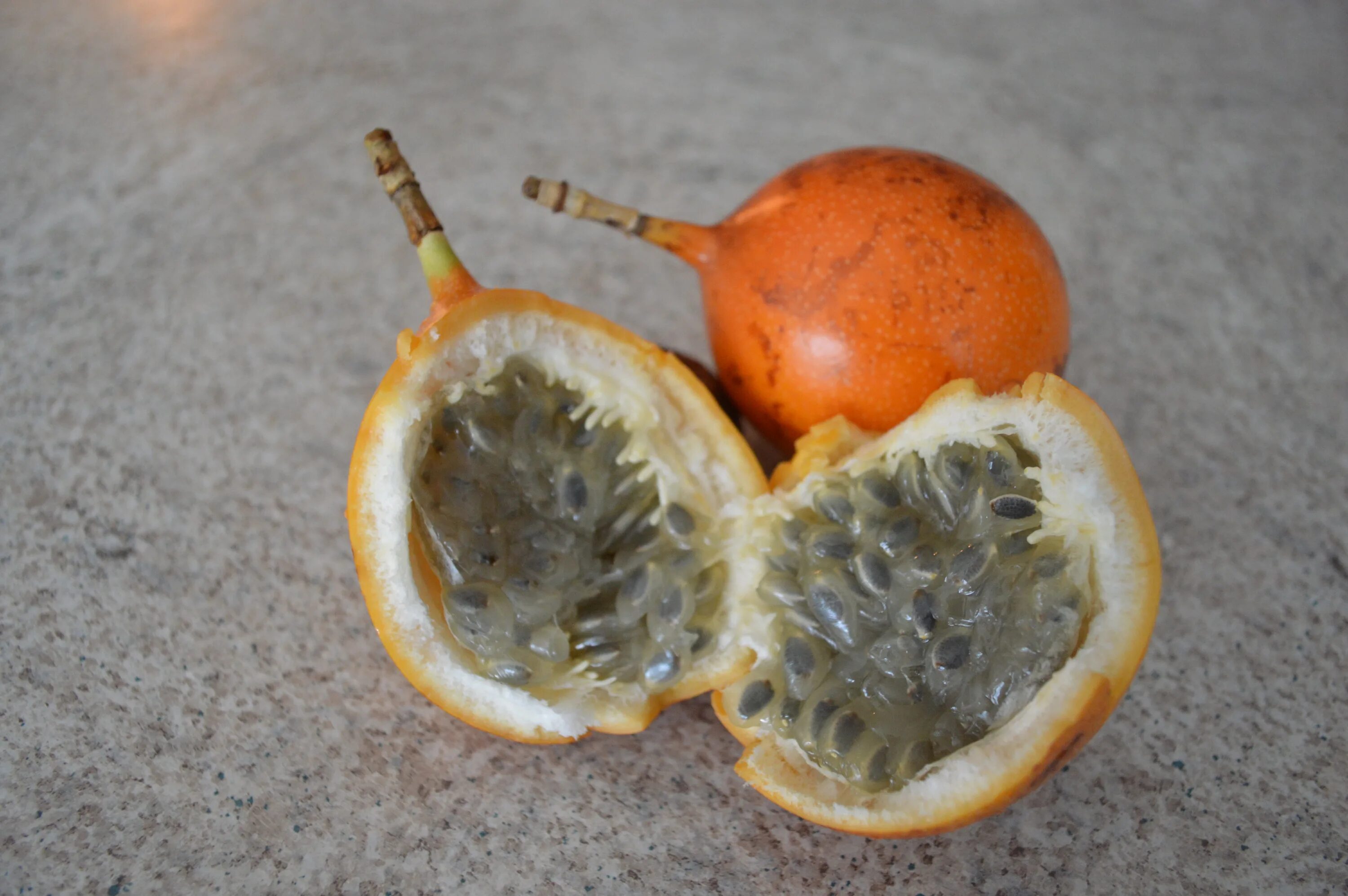 Оранжевый фрукт с черными. Маракуйя гранадилла. Гранадилла Колумбия. Маракуйя и гранадилла фрукт. Маракуйя фрукт оранжевый.