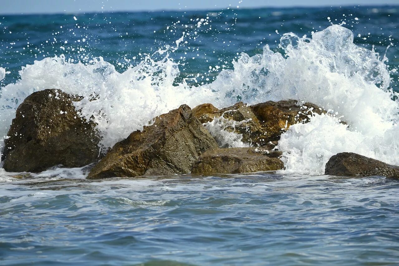 Вода в волне движется. Море камни волны. Волны бьются о камни. Волна разбивается о камень. Брызги моря.