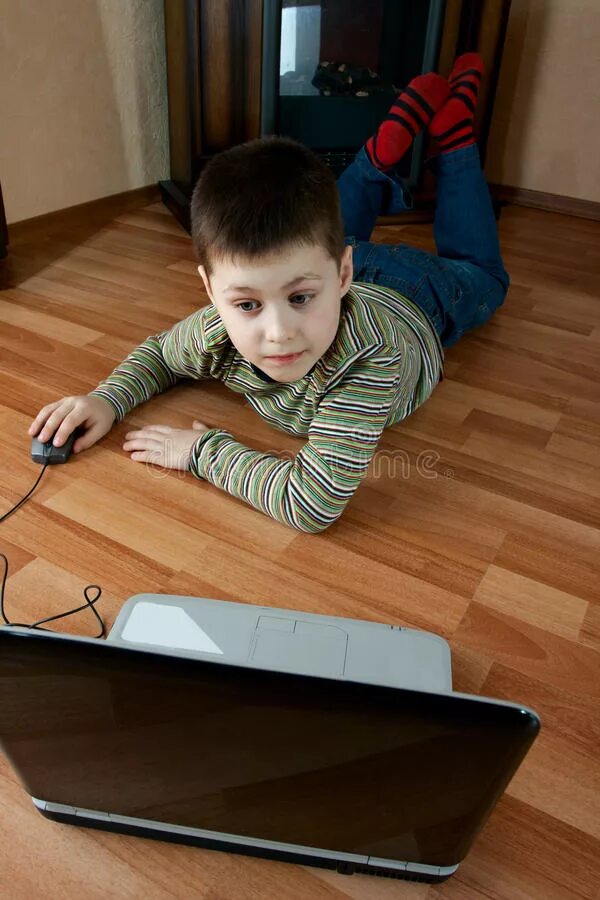 The boy is playing the computer