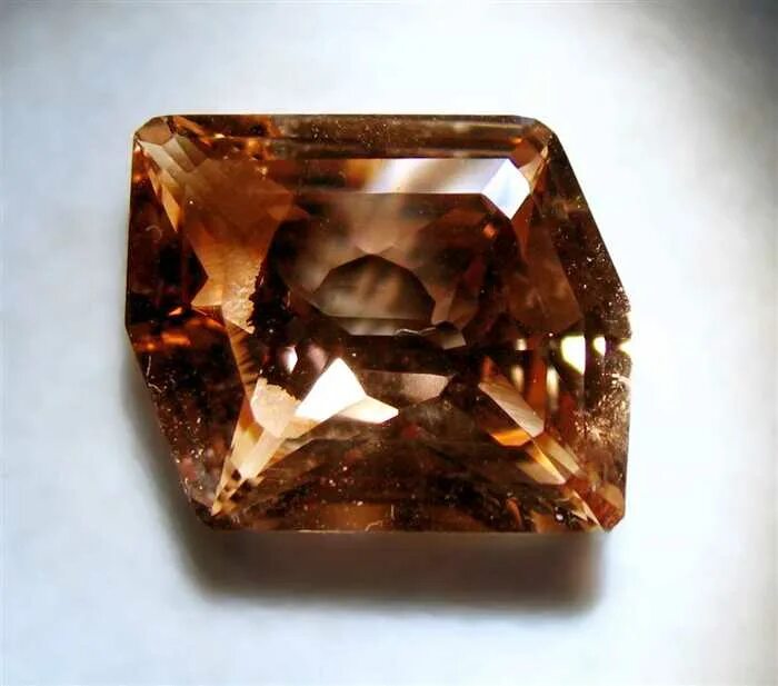 Коричневый полупрозрачный кварц дымчатый топаз минерал. Дымчатый кварц камень. Коричневые драгоценные. Дымчатый топаз камень. Спессартин гранат галтовка.