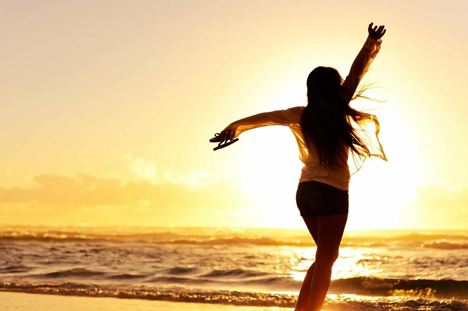 Счастливая девушка. Счастливая девушка на море. Девушка танцует на берегу моря. Девушка у моря с солнцем.