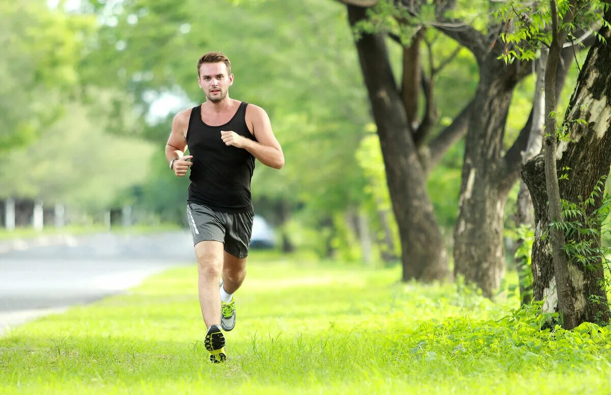 Running white. Парень на пробежке. Мужчина на пробежке в парке. Парень бежит. Бег в парке.