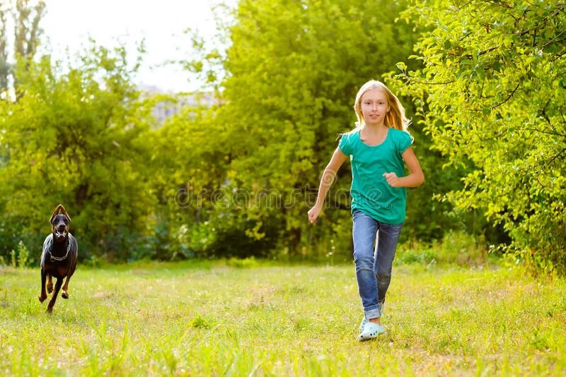 Человек гуляет с собакой. Собака бежит девочку. Пробежка с собакой. Собака бежит девочку. Девушка на пробежке с собакой.