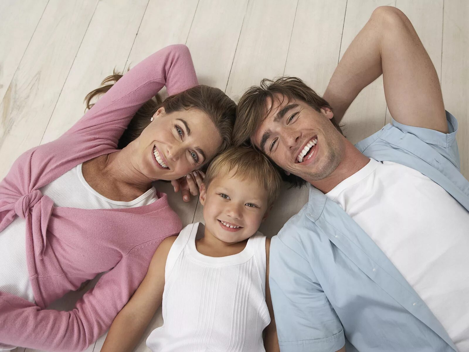 Между сыном и мужем. Родители и дети. Ребенок в семье. Фотография семьи. Семья со счастливым ребёнком.
