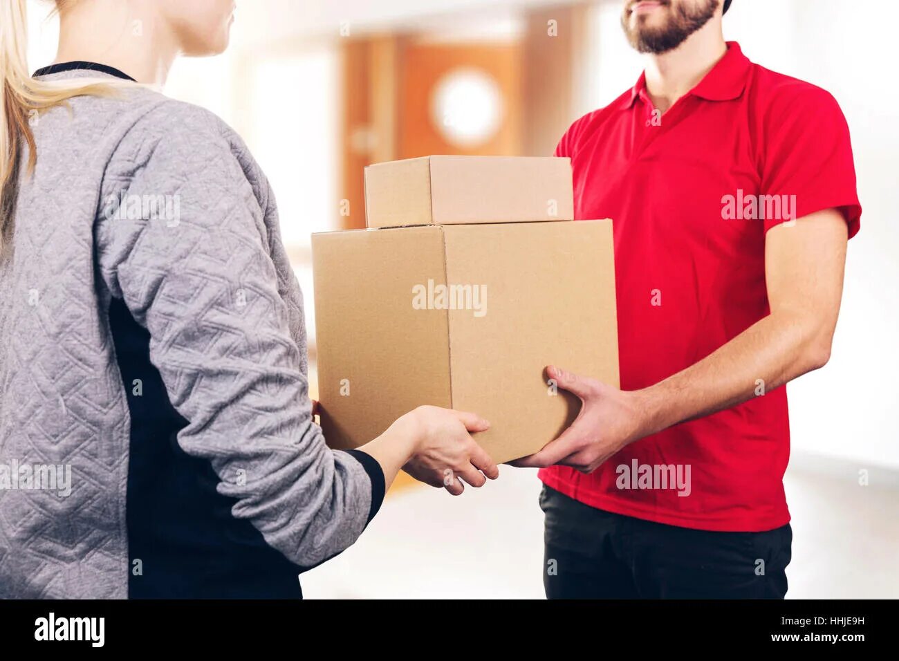 Курьер с посылкой. Buyer delivery. Курьер вручает посылку. Courier hands over boxes. Мужчина держит упаковку.