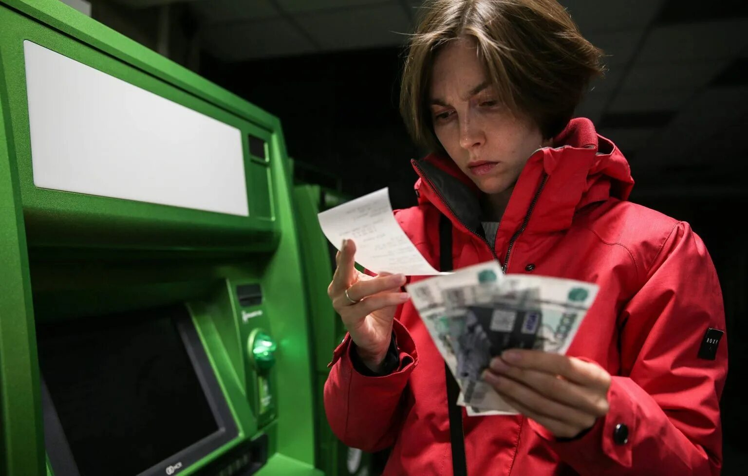 Женщина у банкомата с деньгами. Подросток с деньгами. Женщина переводит деньги. Человек пересчитывает деньги.
