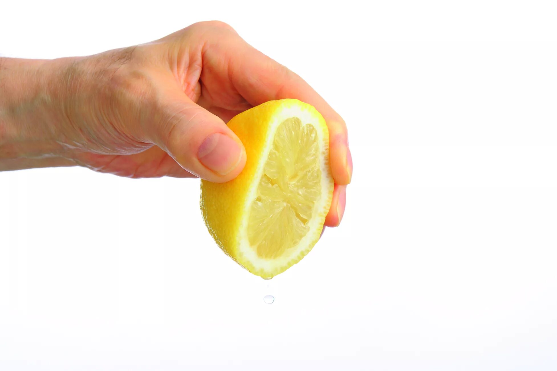Выжимает сок лимона. Сок лимона на белом фоне. Выдавить лимон. Рука выжимает лимон. И немного сока лимона