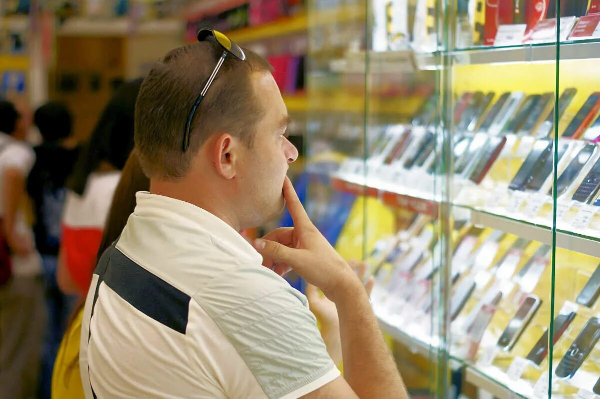 Выбор смартфона. Человек выбирает телефон. Телефон в руке фото. Покупатель выбирает смартфон. Выбор телефона.