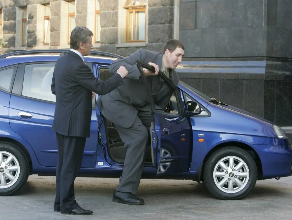 Высокий человек в маленькой машине. Высокие водители. За рулем kia sportage. Автомобилист за рулем. Высокие водители.