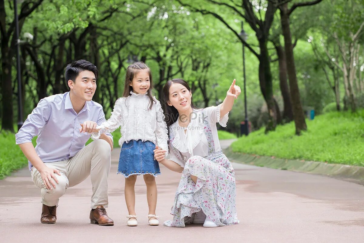 Семья азиаты в парке. Китайская семья в парке. Папа с дочкой китайцы соревнуются дома.