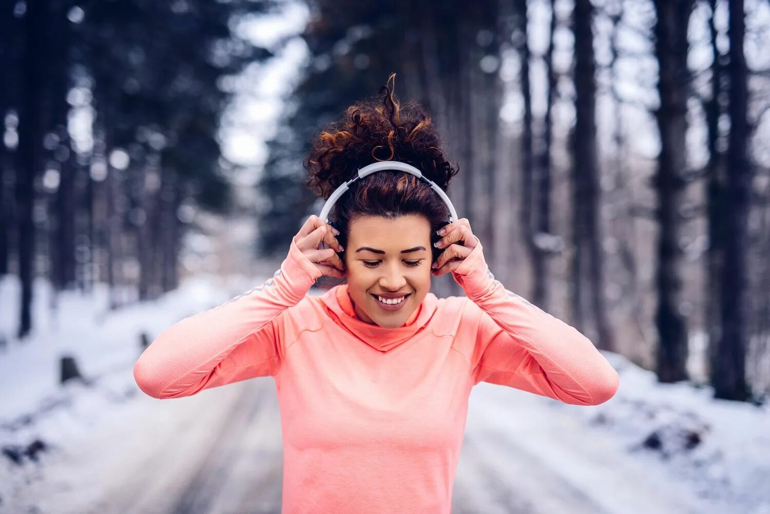 Музыка бег. Девушка надевает наушники. Бег в наушниках зимой. Плейлист для пробежки. Люди СЛУШАЮТ музыку зимой.