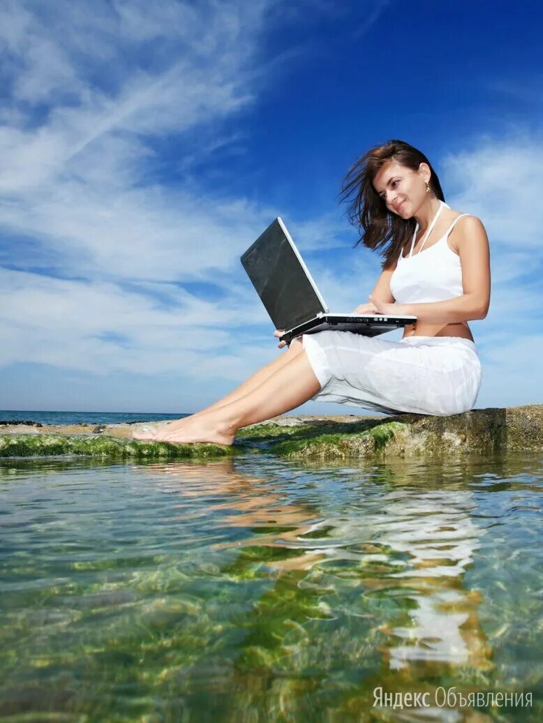 девушка с ноутбуком на берегу моря. удаленная работа совмещение.