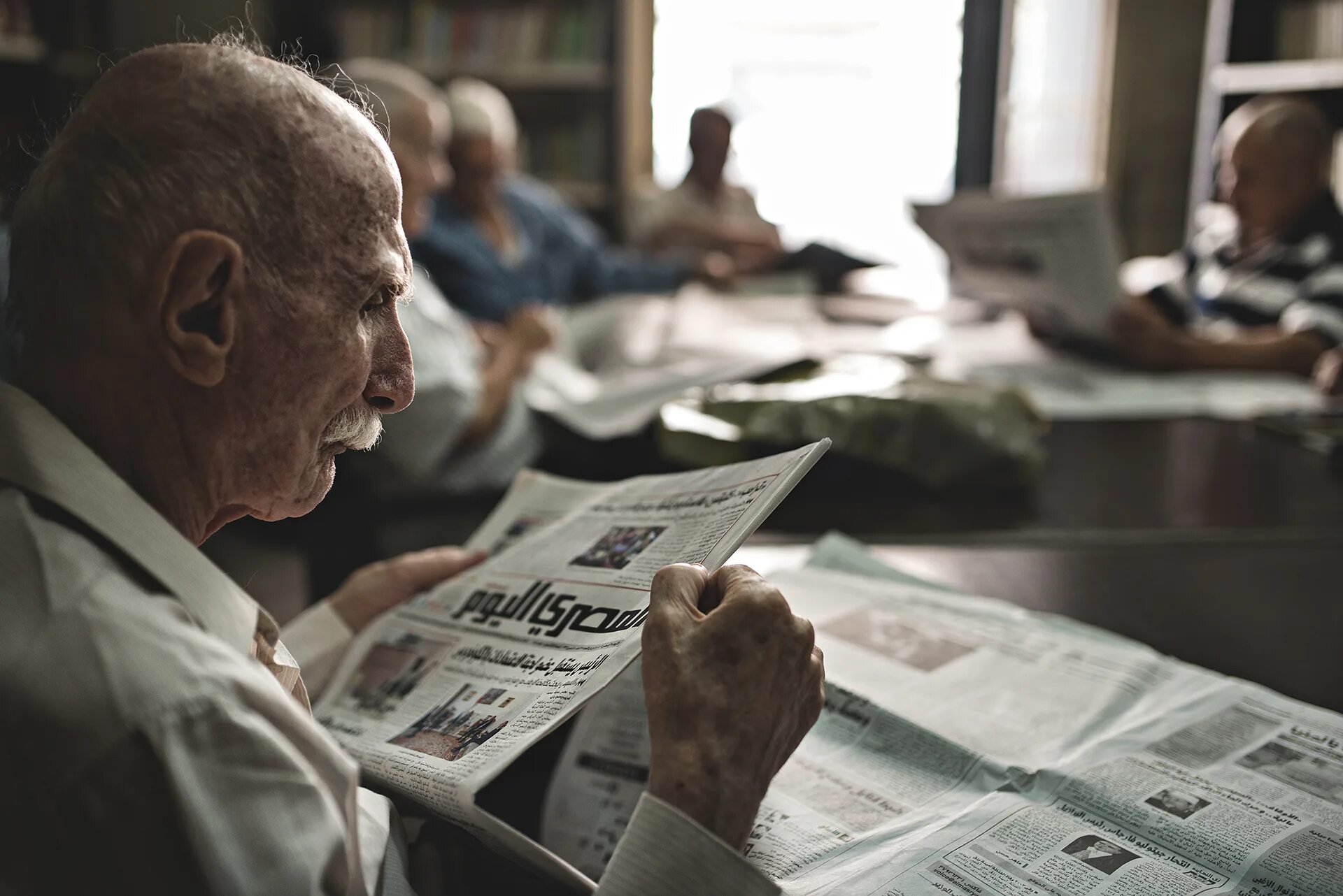 I was were reading a newspaper. Old man reading newspaper at Home Vintage. Old man reading newspaper at Home Retro photo.