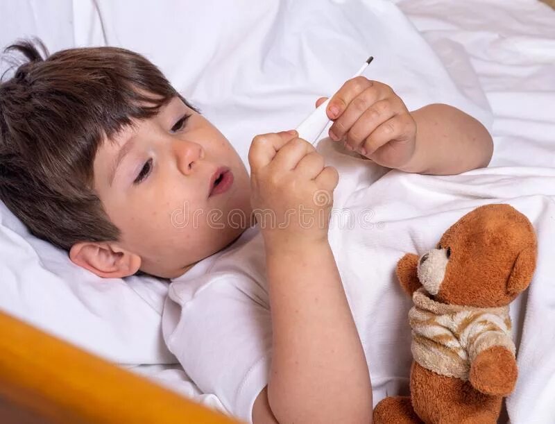 Больный. Больной ребенок в постели с термометром и игрушкой. Малыш в кровати температура. Ребенок с температурой в кровати. Фото больного ребенка с температурой.