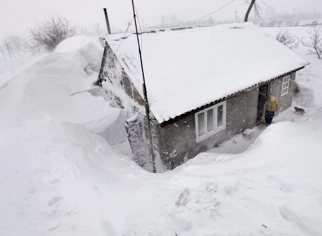 Заваленные снегом дома. Сугробы в деревне. Дом заваленный снегом. Деревню замело снегом. Домики заваленные снегом в деревне.