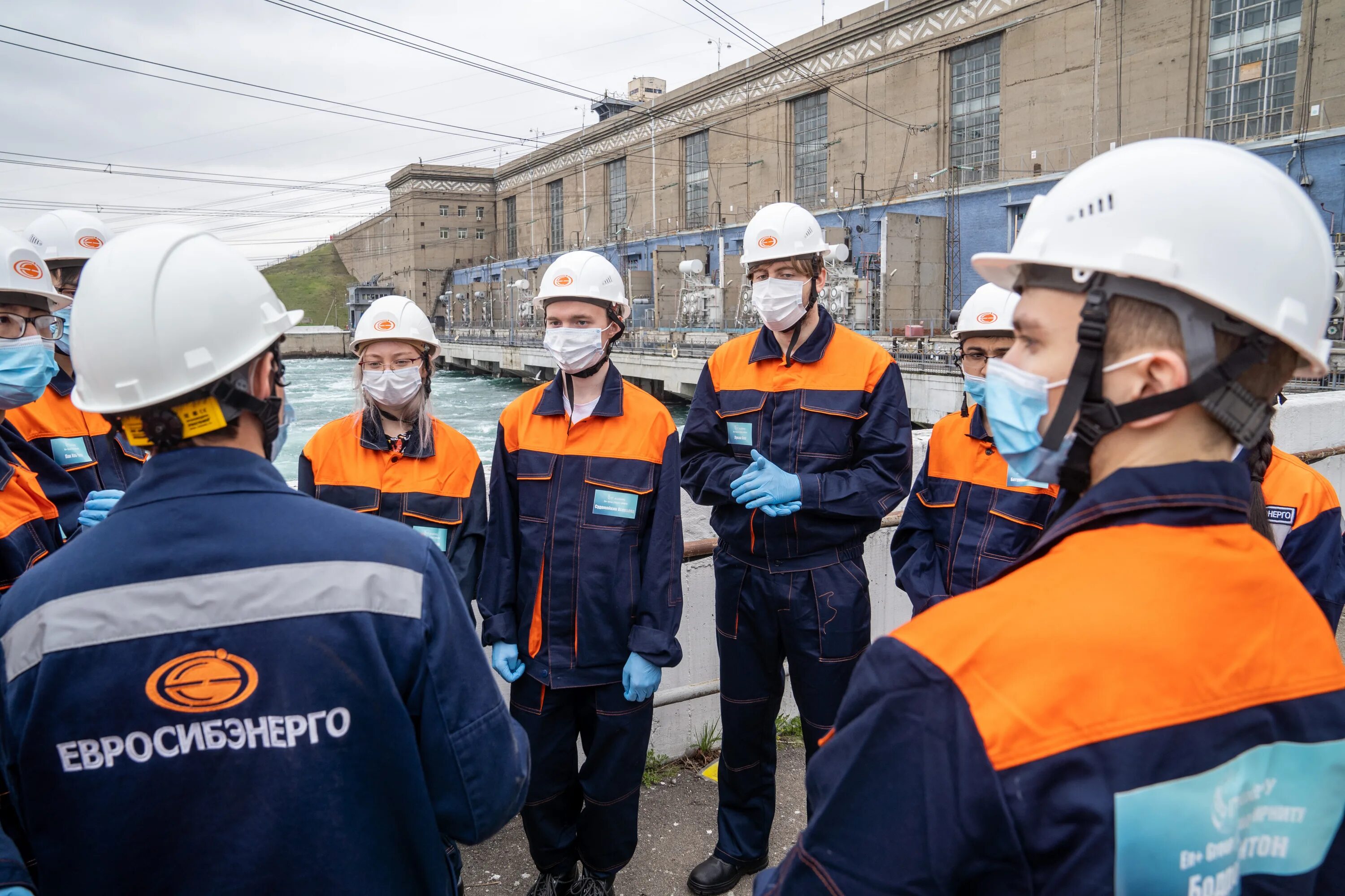 Радостные люди в офисе. Оранжевый комбинезон мужской. Rewarding job. Туризм и гостиное дело. Ао энсер г.
