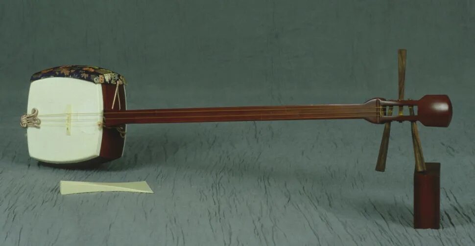 Японская трехструнная лютня с длинной шейкой. Сямисэн музыкальный инструмент Япония. Японский струнный инструмент сямисэн. Плектр для сямисэна. Сямисэн хосодзао.